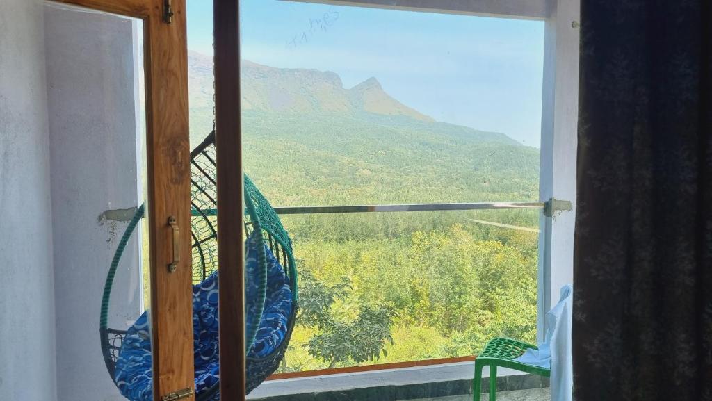 a window with a view of a mountain at The Inchara Vista in Chikmagalūr
