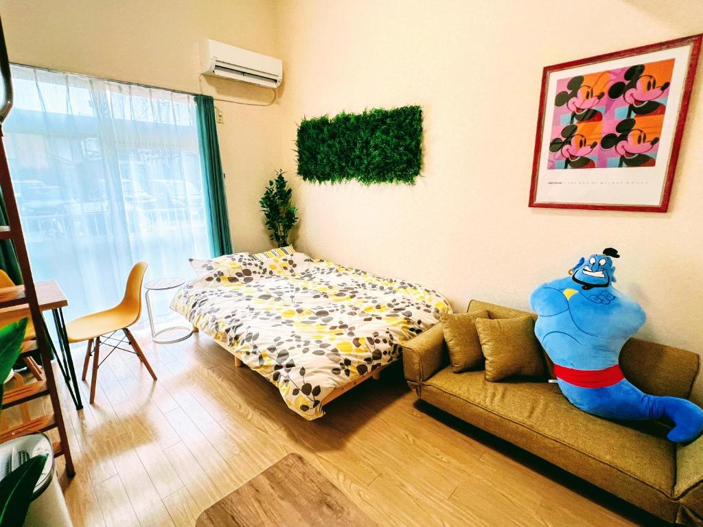 東京的住宿－メゾンクレスタ，客厅配有沙发和1张床