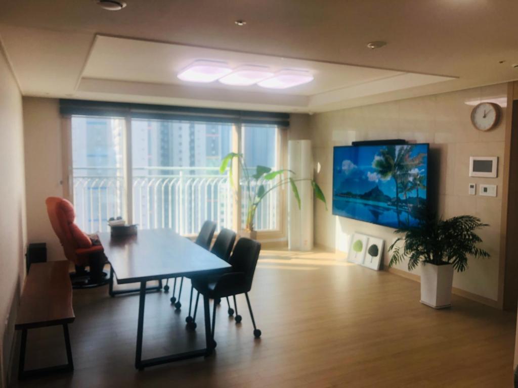 - une salle à manger avec une table, des chaises et une télévision dans l'établissement Bluepant's homestay, à Namyangju