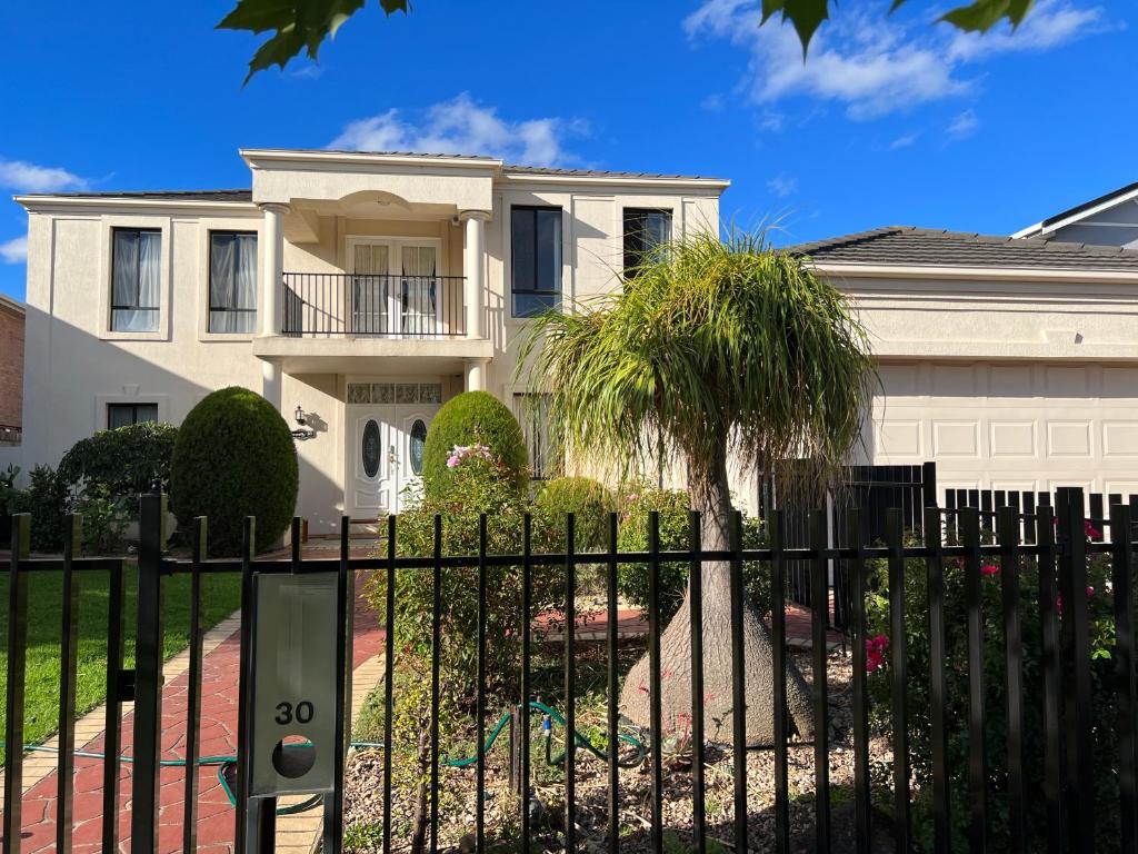 una casa con una valla y una palmera en Happy Post - New en Taylors Lakes