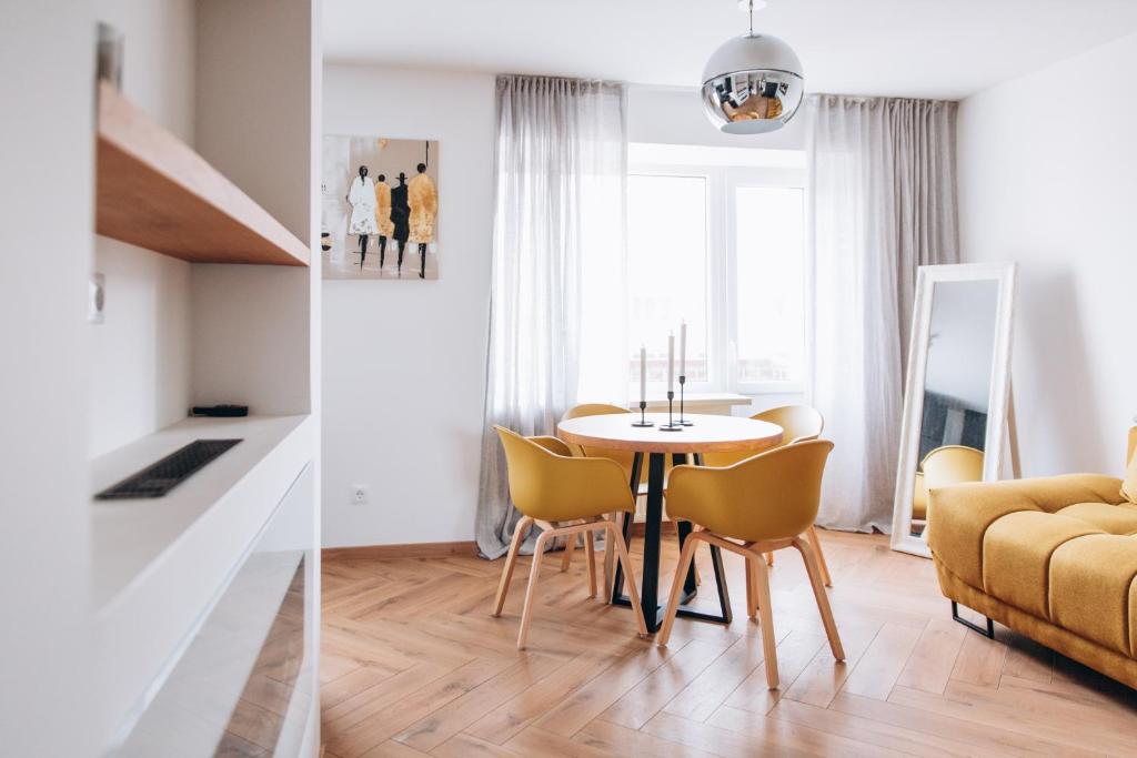 a dining room and living room with a table and chairs at Seaside Apartment in Liepāja