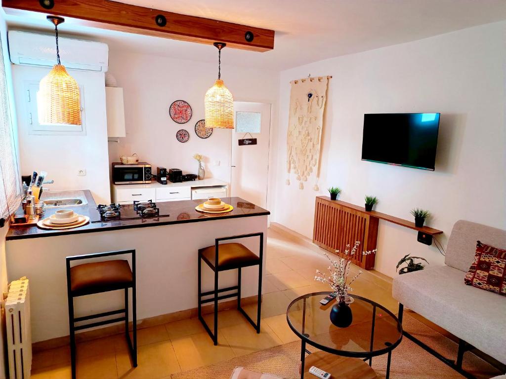 a small kitchen and living room with a counter and a table at Ideal Appart Marsa Les Palmiers in La Marsa
