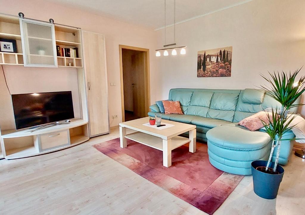 a living room with a blue couch and a table at Ferienwohnung Weißes Ross in Pirna