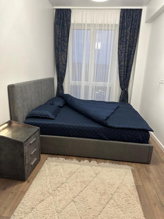 Bett in einem Zimmer mit Fenster in der Unterkunft Apartament lângă VIVO in Floreşti