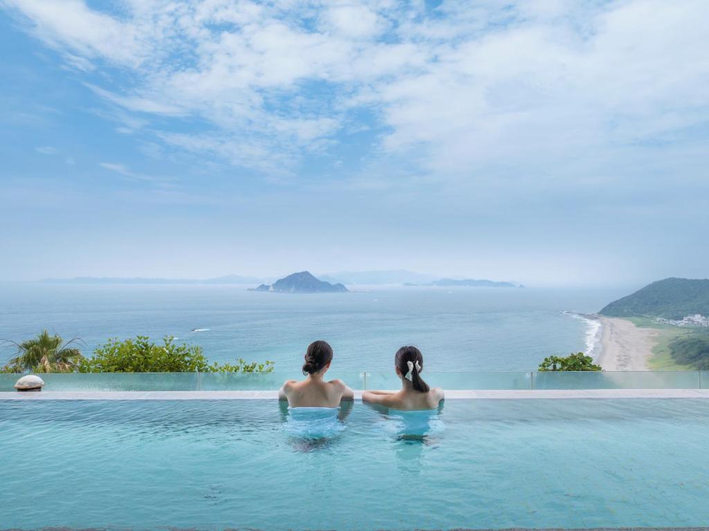 two women sitting in a infinity pool looking out at the ocean at Irago Ocean Resort in Tahara