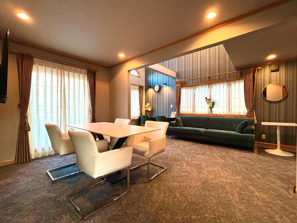 Five room 120 #SKY TREE #SENSOJI #FreeParking 1292sqft في طوكيو: غرفة معيشة مع طاولة وكراسي وأريكة
