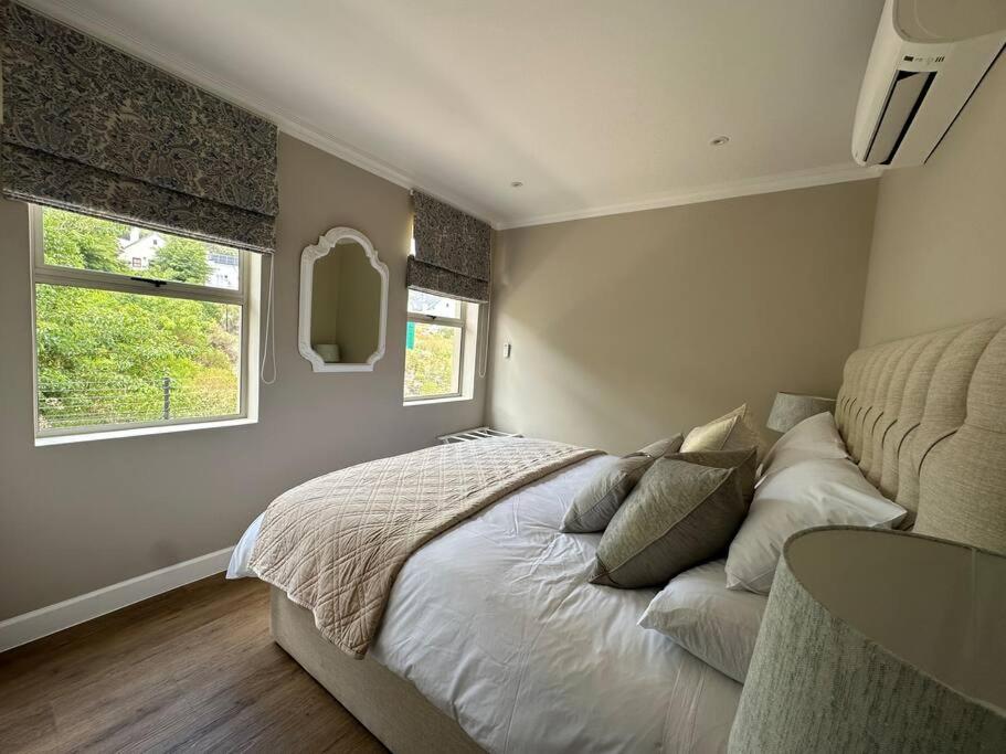 1 dormitorio con 1 cama grande y 2 ventanas en Mountain View 1-Bedroom Villa in Franschhoek en Franschhoek