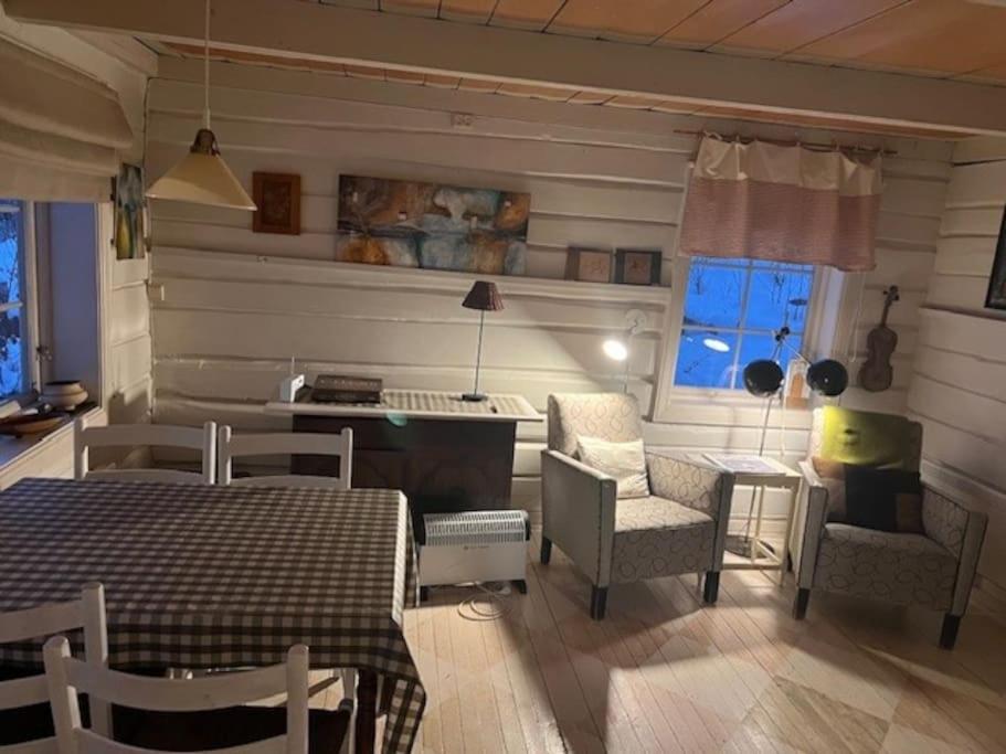 sala de estar con mesa, sillas y escritorio en Det røde huset på Vågnes, en Krokelvdalen