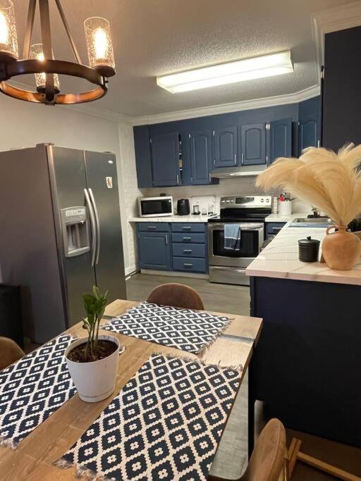 a kitchen with blue cabinets and a table with a potted plant at Cozy1King1Queen/1.5bth2min Frm UpTown in Lexington