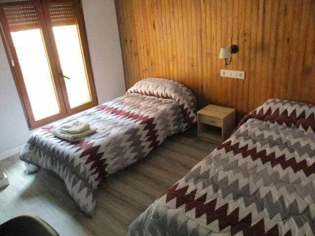 1 dormitorio con 2 camas y ventana en Casa Rural La Malena, en Azuara