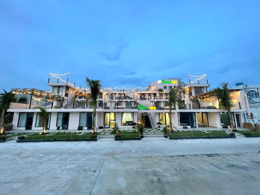 un grande edificio con palme di fronte di Queen Sea Resort - Đảo Phú Quý a Cu Lao Thu