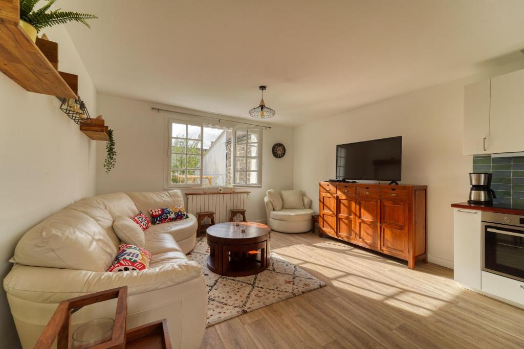 a living room with a couch and a tv at Chic and modern house with parking garden and gym in Saint-Denis