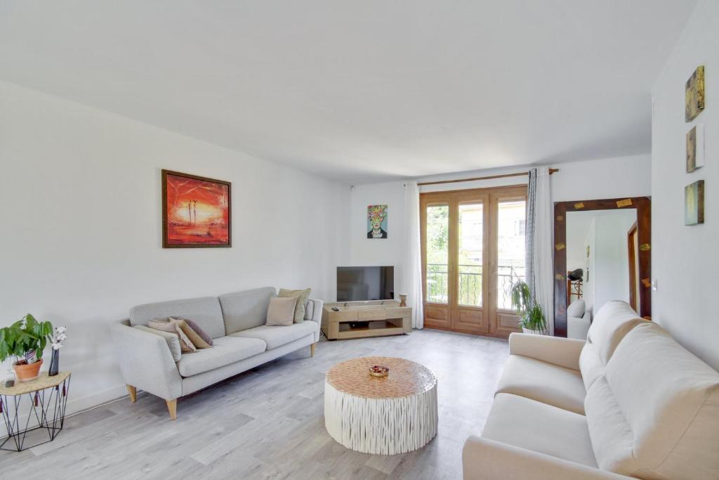 a living room with two couches and a tv at Authentic family home in Neuilly-sur-Marne in Neuilly-sur-Marne