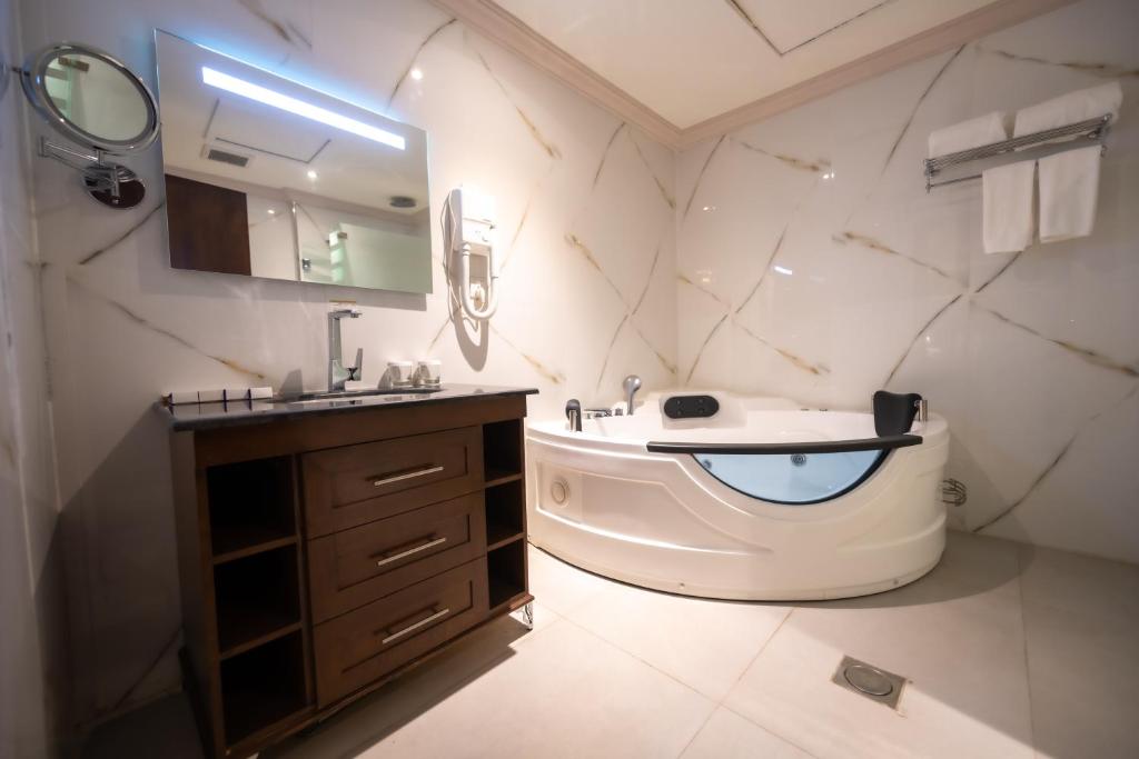فندق دبليو اي في جدة: حمام مع حوض وحوض استحمام ومرحاض