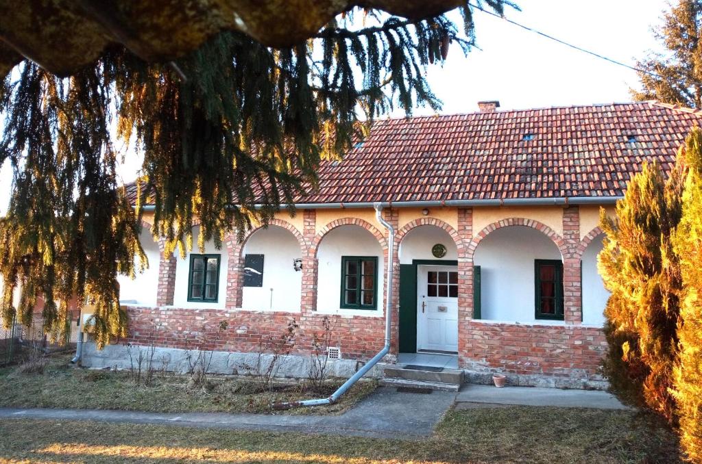 une maison en briques avec un toit rouge dans l'établissement Jelkő Ház Terpes, 