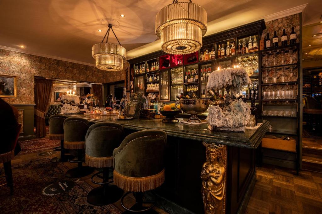 a bar in a restaurant with a counter and chairs at Hotel Pigalle in Gothenburg