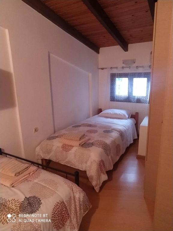 two beds in a room with two windows at Casa del Sol in Arónion