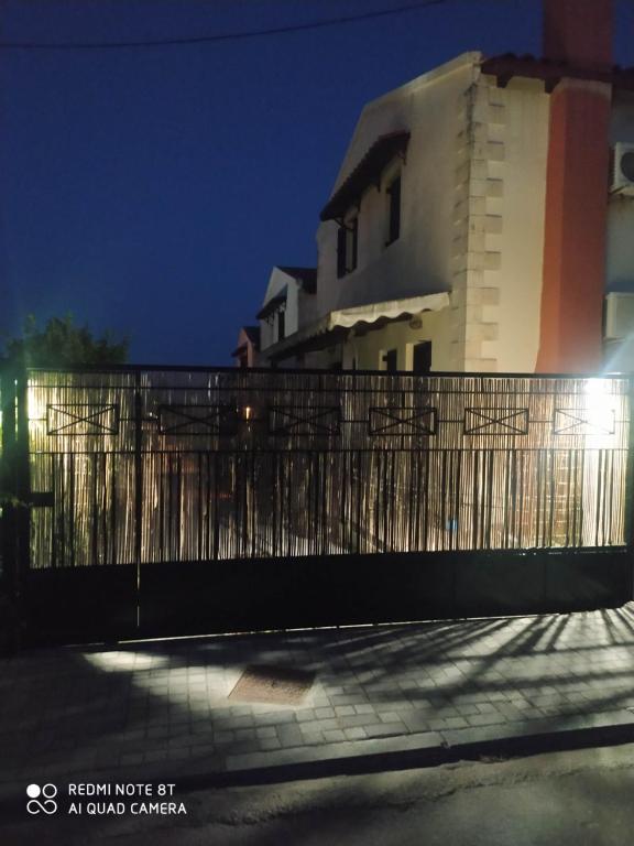 a fence in front of a house at night at Casa del Sol in Arónion
