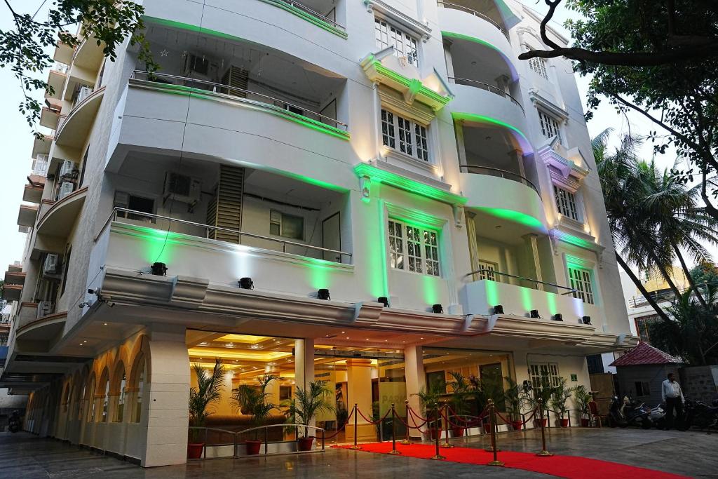 - un grand bâtiment blanc avec des lumières vertes dans l'établissement Hyde Park Aparthotel, à Bangalore