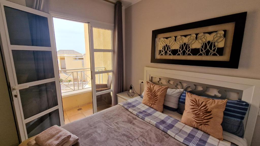 a bedroom with a bed with a view of a balcony at Residencial Benimar Licencia Vv in Adeje