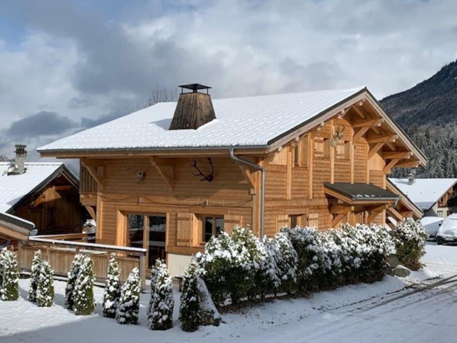 a large log cabin with snow on the roof at Individual chalet for up to 12 people maximum in Les Contamines-Montjoie