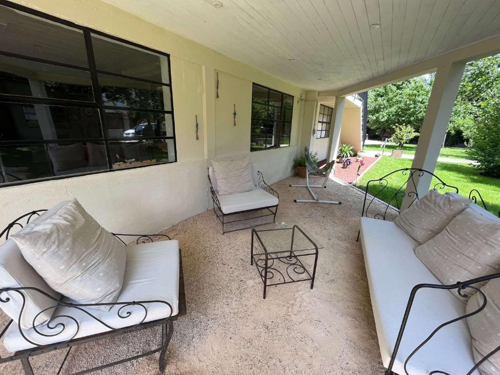 a porch with two white couches and a table at Le Jardin du Dolaizon in Le Puy-en-Velay