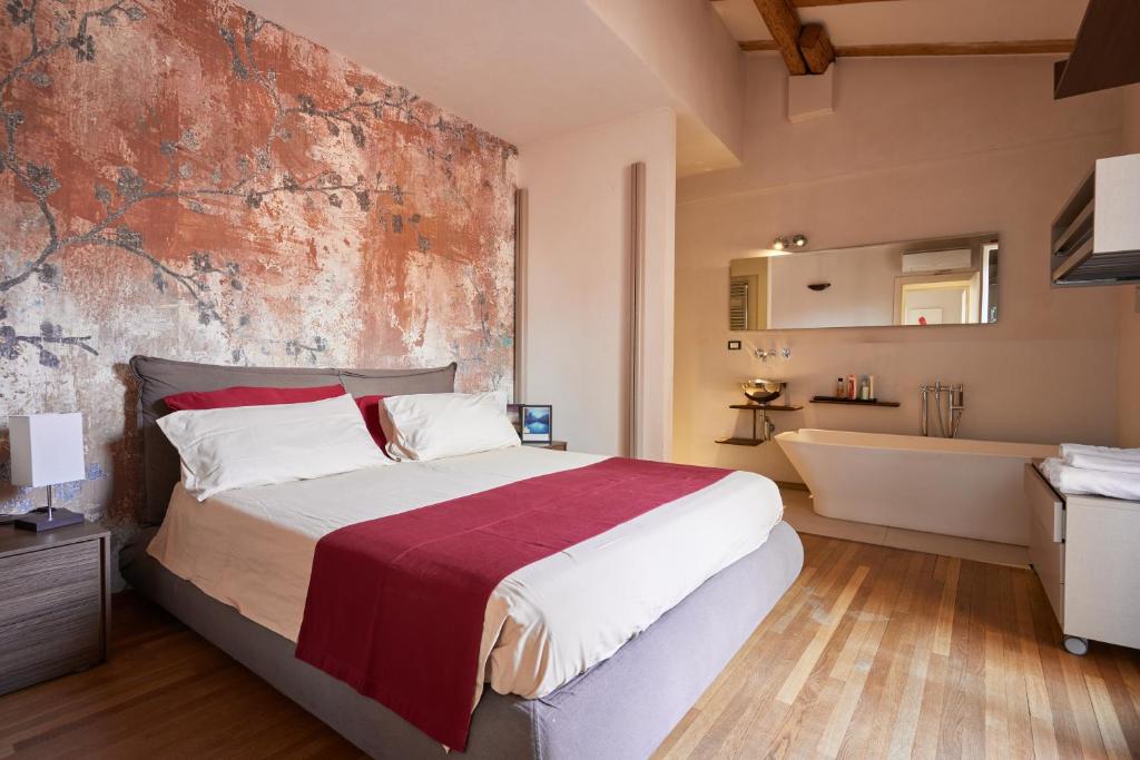 um quarto com uma cama, uma banheira e um lavatório em Bright and Peaceful Apartment in Historic Palazzo em Bolonha