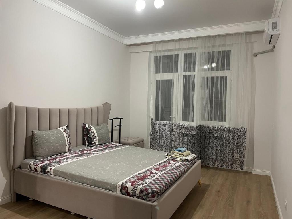 a bedroom with a bed and a window at ЖК Три короны in Aktau