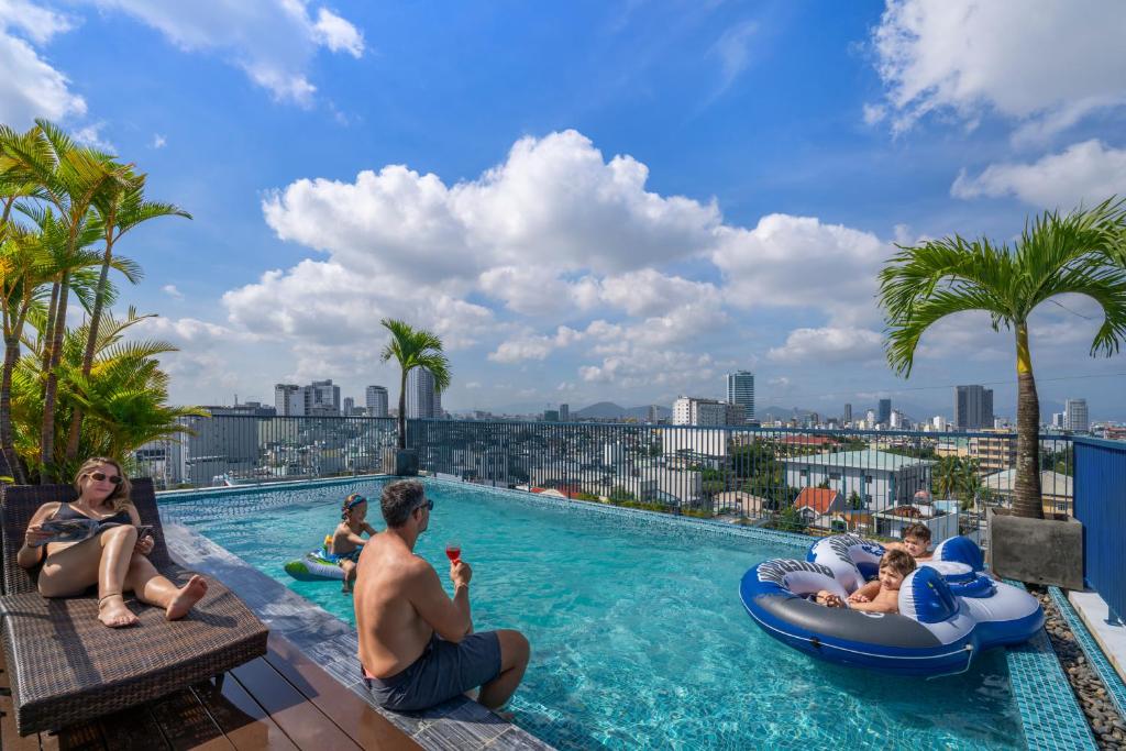 een groep mensen in het zwembad van een resort bij Dana House ELC in Da Nang