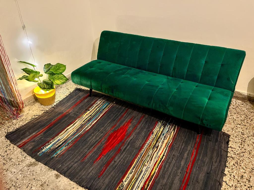 eine grüne Couch auf einem Teppich im Wohnzimmer in der Unterkunft Bliss Studio’s - Entire 1 BHK Apartment in Nagpur