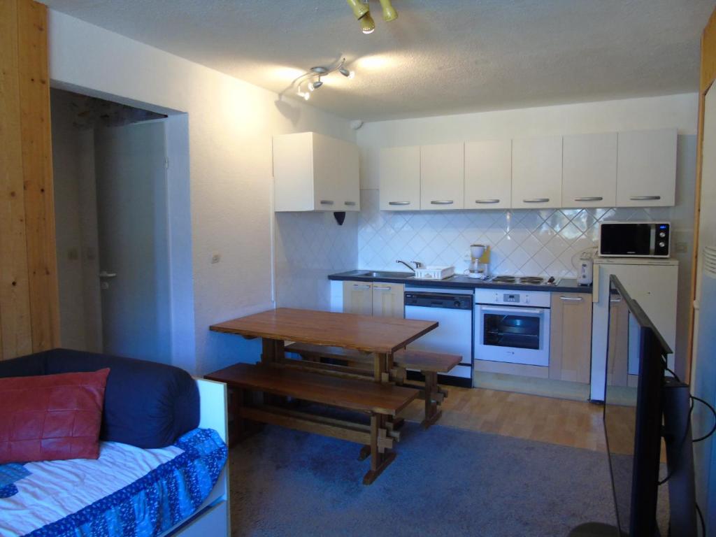 une petite cuisine avec une table et un canapé dans l'établissement Appartement cosy 3 pièces pour 6 pers. à Valfréjus, proche télécabine et commerces, avec balcon - FR-1-561-65, à Modane
