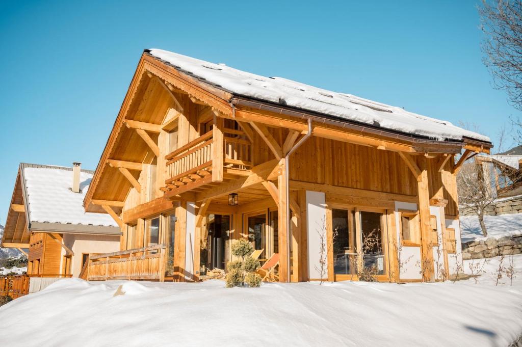 a log cabin with snow on the roof at Chalet Ski Académie - Serre Chevalier in Saint-Chaffrey