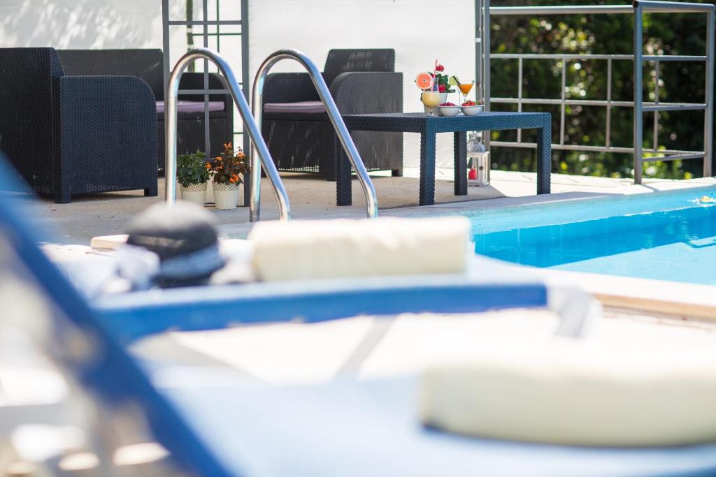uma piscina com uma mesa ao lado de uma piscina em RELAXING HOME LUCE em Cilipi