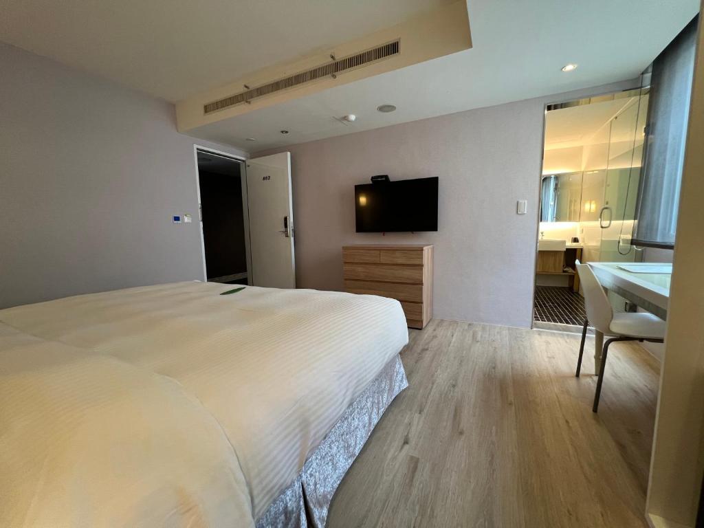 a bedroom with a bed and a desk and a television at 台北馥華商旅 松江館 in Taipei