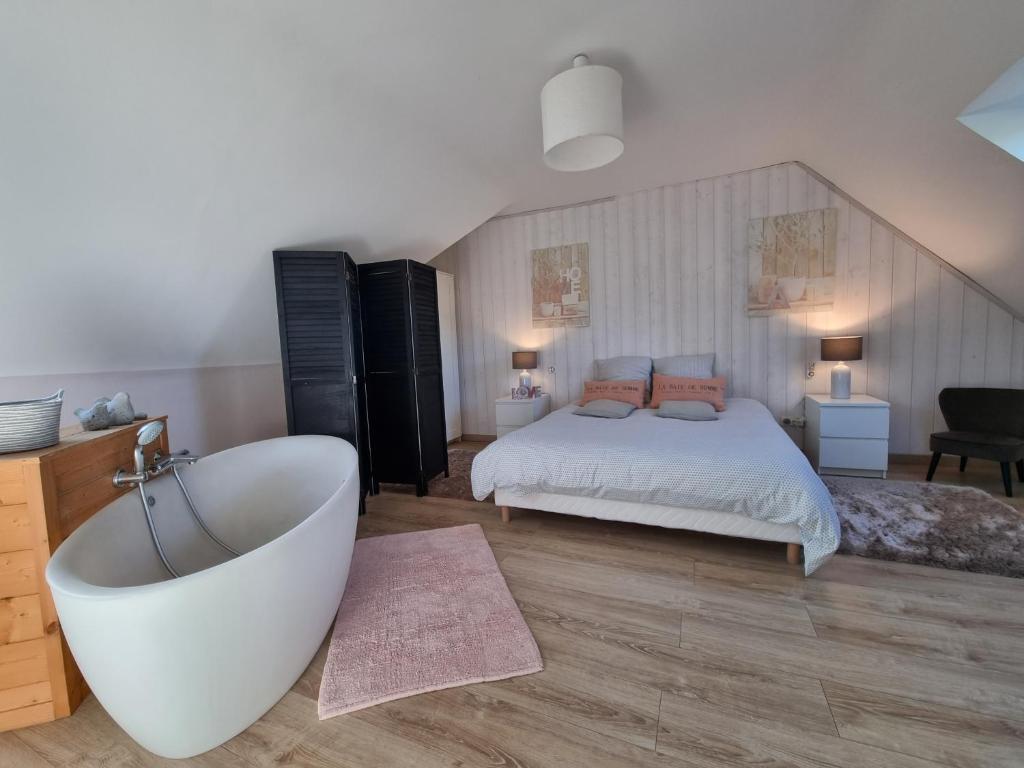 1 dormitorio con bañera y 1 cama en La Ferme d'Antan Baie de Somme, en Mons-Boubert