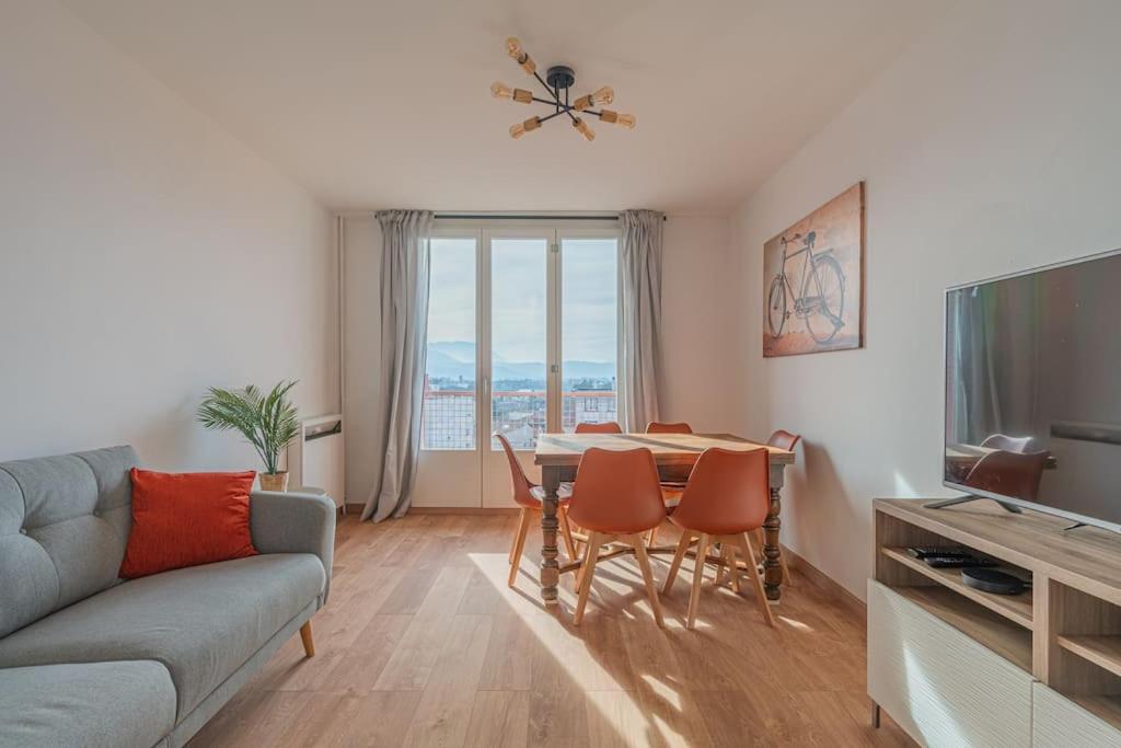 a living room with a couch and a table with chairs at R'Apparts T4 Les Balcons De Belledonne in Rhut