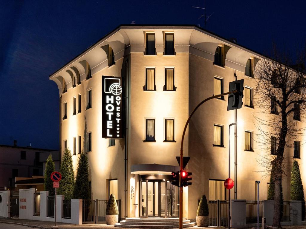 un grande edificio bianco con un cartello sopra di Hotel Ovest a Piacenza