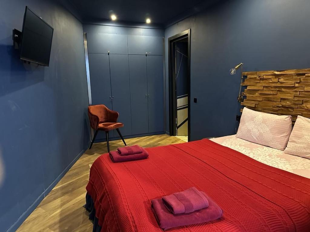 a bedroom with a red bed and a chair at New Gudauri Loft 2 Apartment 129 in Gudauri