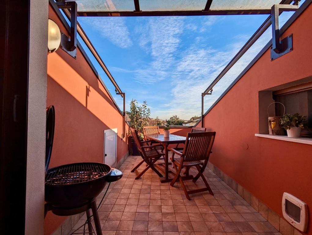 patio con mesa y sillas en el balcón en Cozy Family Retreat/ 5 pl/ 1h drive from Venice, en Caldiero