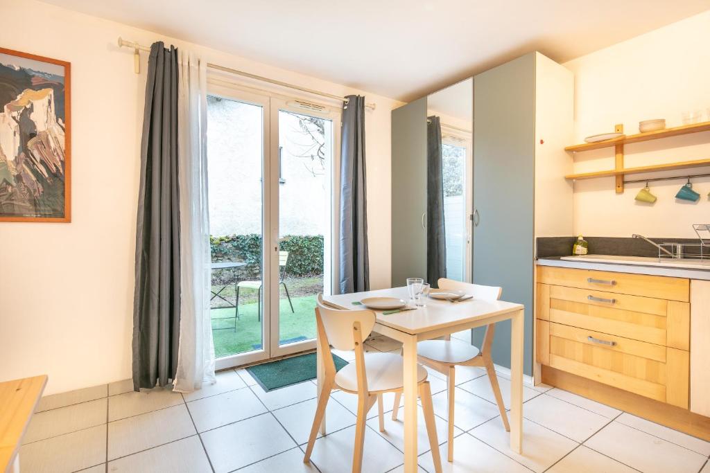 eine Küche mit einem Tisch und Stühlen sowie einem Fenster in der Unterkunft Studio 3 Oisans - Terrasse et parking privé in Meylan