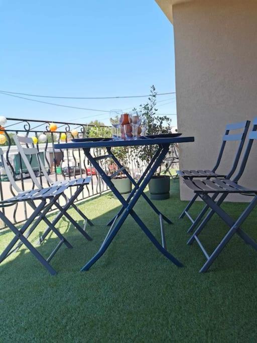 deux chaises et une table sur un balcon dans l'établissement Dark blue Appartement 2 chambres climatisation parking 900m des remparts, à Avignon