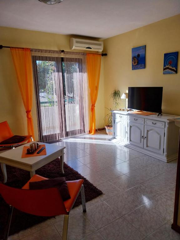 a living room with a tv and a couch and a table at Apartment Svagi in Split