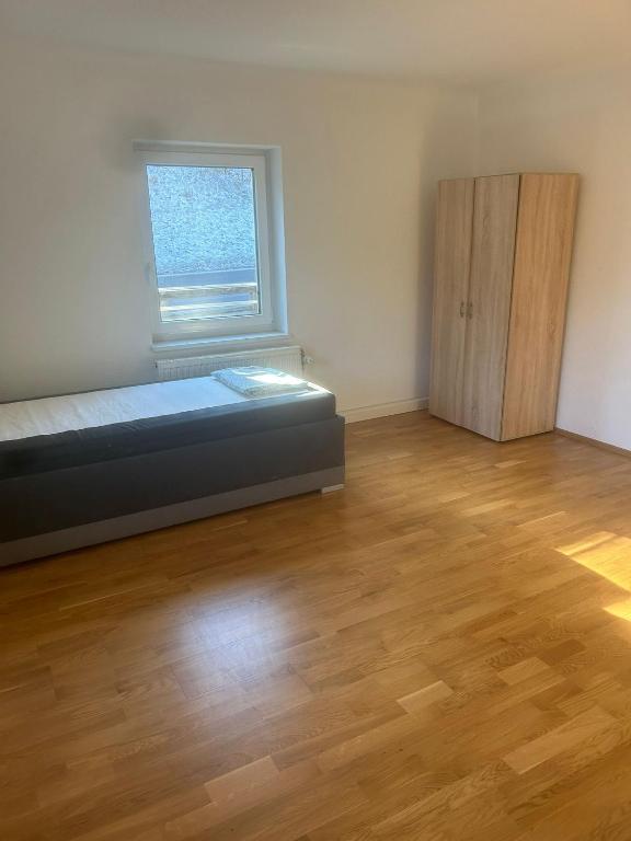 um quarto com uma cama, uma janela e um piso de madeira em Montel PARK - Nizza em Landl