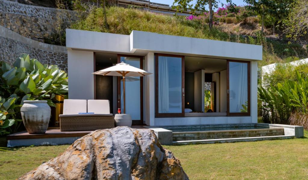 a house with a large rock in the yard at Selong Selo Resort and Residences in Selong Belanak