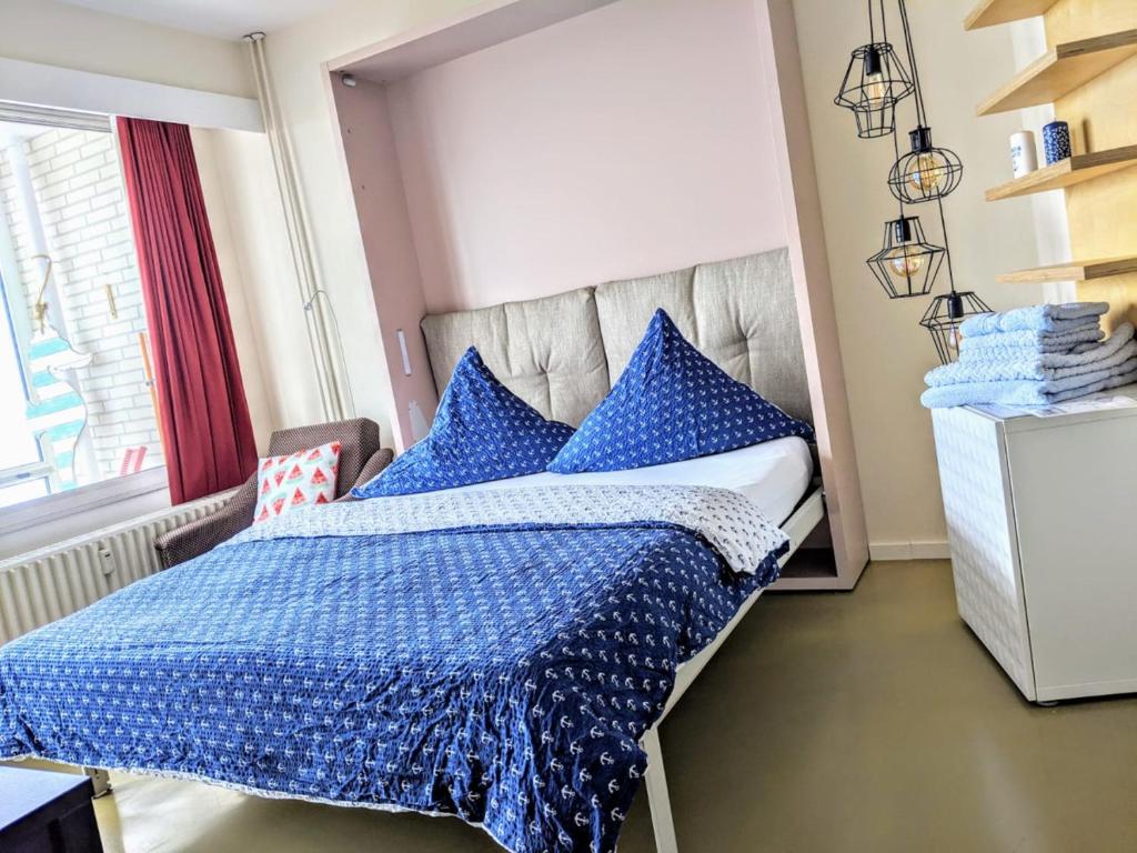 ein Schlafzimmer mit einem blauen Bett mit blauen Kissen in der Unterkunft Seehütte Ferienwohnung 507 in Cuxhaven