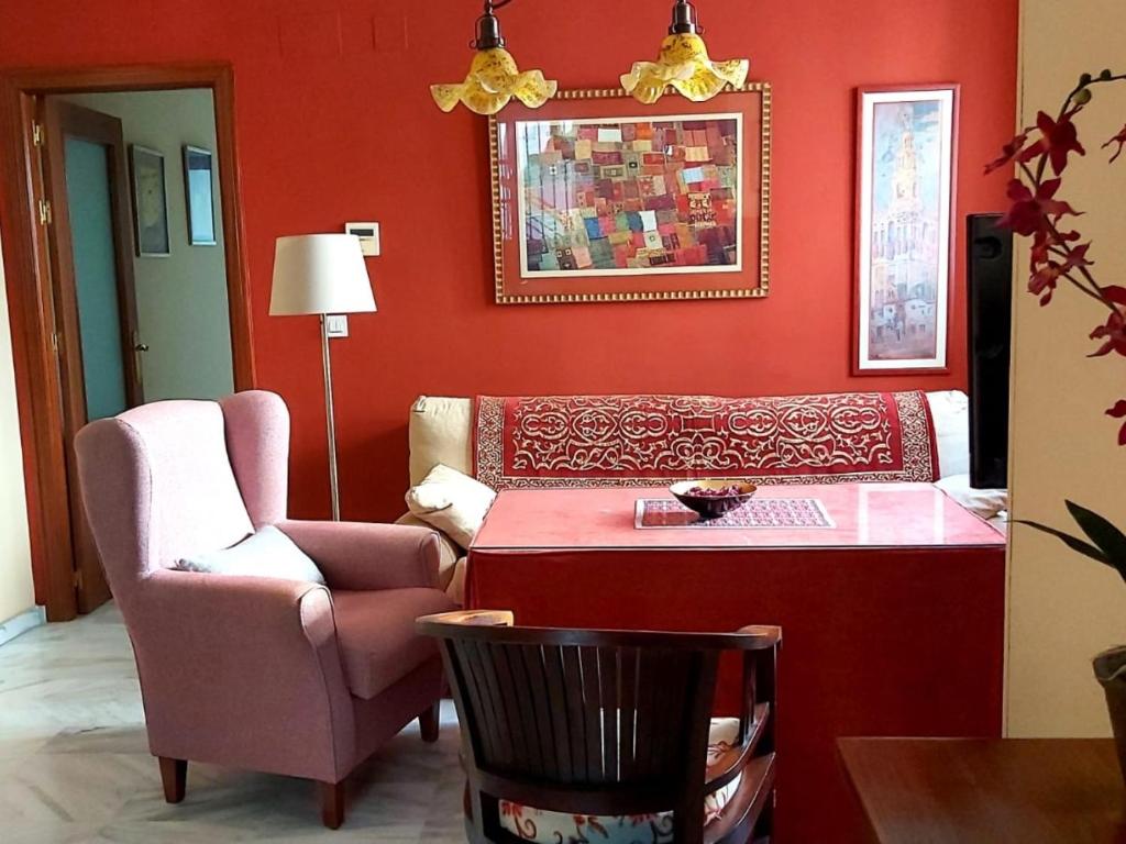 a red living room with a chair and a table at Junto a la Calle Betis: El corazón de Triana in Seville