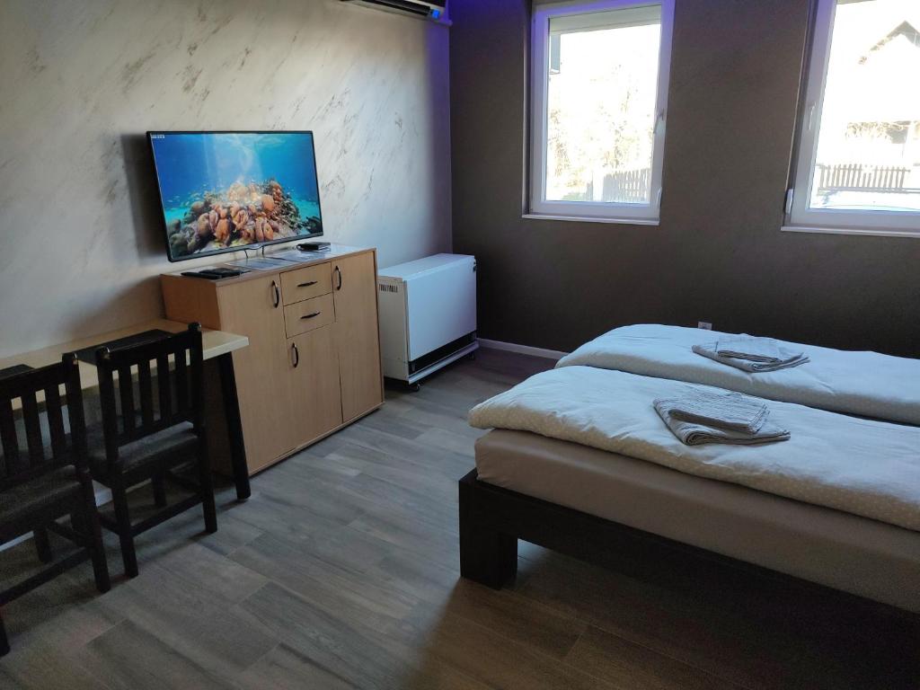 a room with two beds and a flat screen tv at Left Coast studio apartment in Belgrade