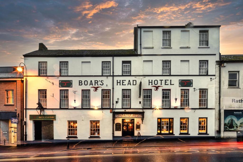 Boars Head Hotel في كرمرثن: مبنى ابيض كبير مكتوب عليه راس فندق