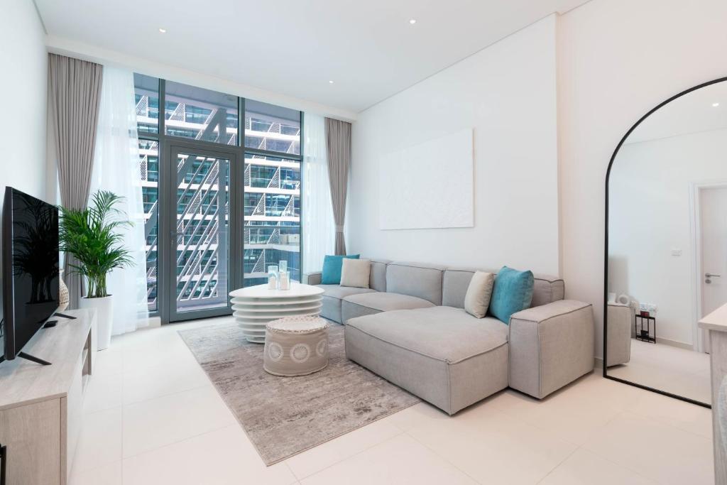 uma sala de estar com um sofá e uma televisão em Tamm - Prime Residence with Unrivaled Palm Jumeirah Views em Dubai