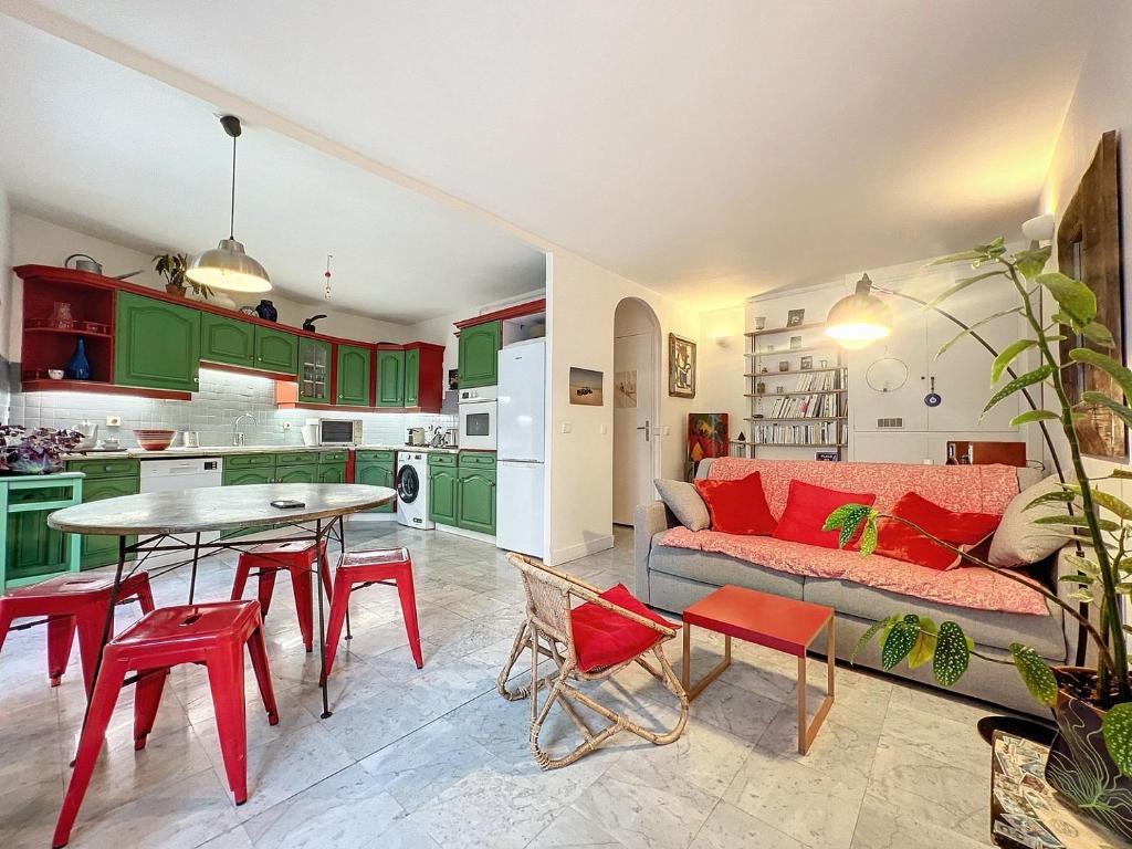 een woonkamer met groene kasten en een tafel en stoelen bij Bijou de la Corderie - Hyper Central & Spacieux - Les Frères de la Loc' in Parijs
